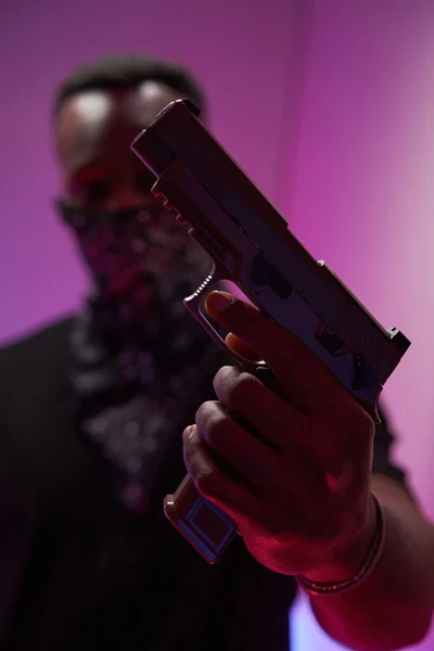 Person showing handgun to camera in studio — Stock Photo, Image