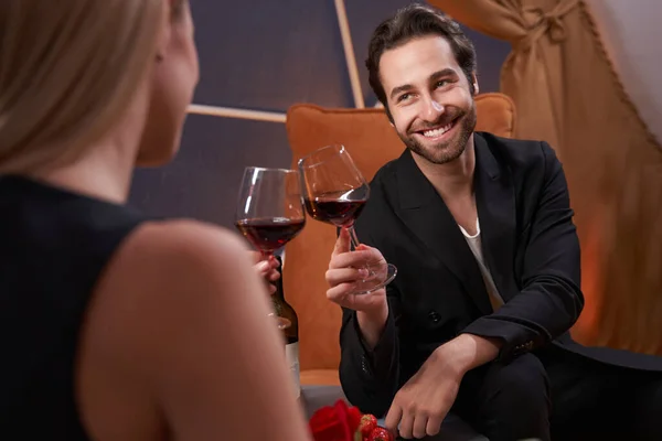 Happy man clinking glasses of wine with his girlfriend — Stockfoto
