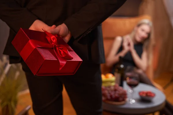 Gift, held by man behind his back in restaurant — Stockfoto