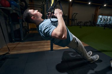 Konsantre sakin sporcu tamamen direnç egzersizi yapıyor.