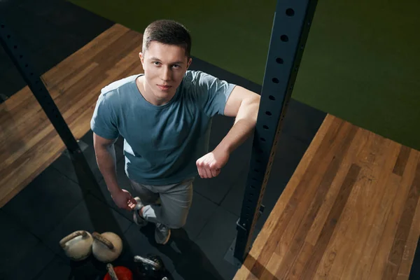 Desportista satisfeito em pé na sala de fitness durante sessão de fotos — Fotografia de Stock