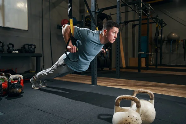 Geconcentreerde jonge sporter die krachttraining doet — Stockfoto