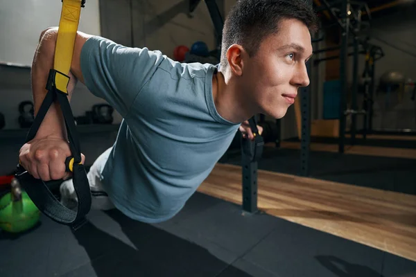 Angenehmes Sportlertraining auf Fahrwerkstrainern im Fitnessstudio — Stockfoto