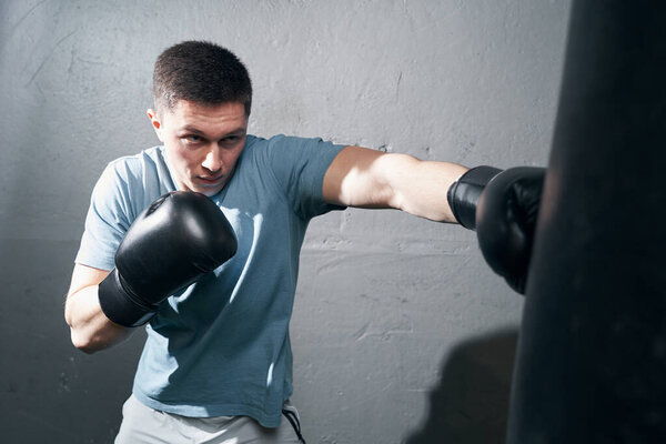 Focused young Caucasian male boxer training indoors