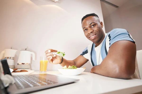 Hombre sonriendo mientras almuerza en casa —  Fotos de Stock