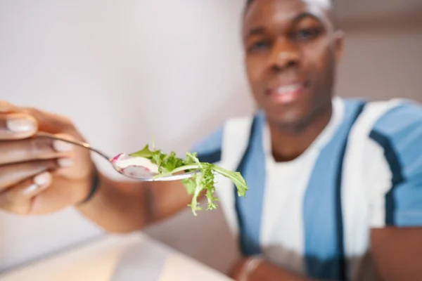 Masculino oferecendo um pedaço de salada em garfo — Fotografia de Stock