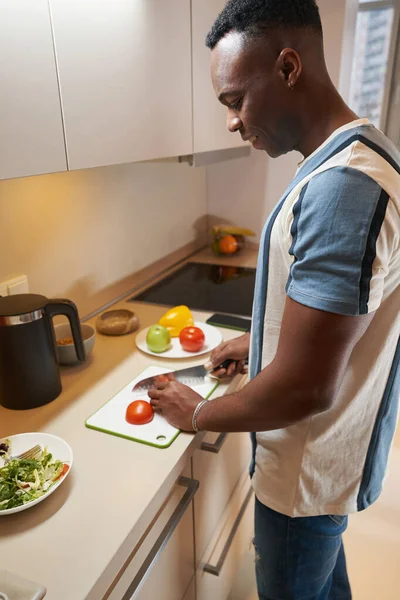 Hombre de raza mixta cocina comida en la cocina —  Fotos de Stock