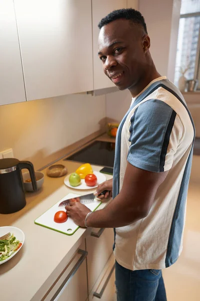 Hombre multiétnico girando a la cámara durante la cocina —  Fotos de Stock