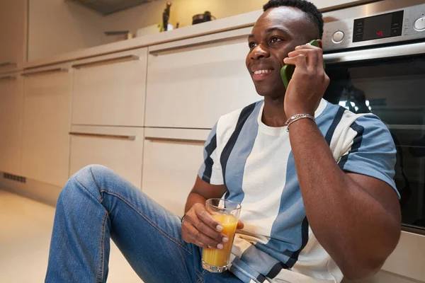 Homem no chão na cozinha ter um telefonema — Fotografia de Stock