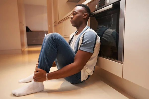 Triste homem multiétnico sentado na cozinha — Fotografia de Stock