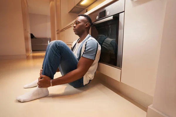 Deprimido masculino descansando no chão na cozinha — Fotografia de Stock