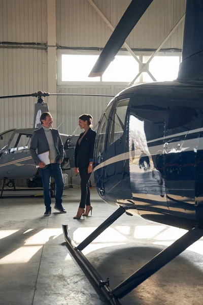 Uçak hangarında sohbet eden iki kişi.