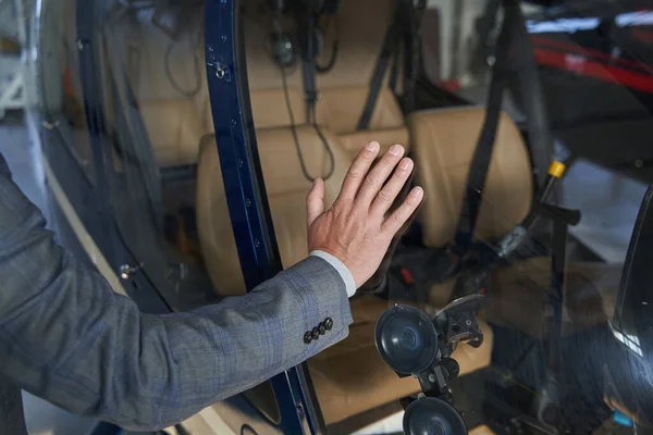 Człowiek opierający się jedną ręką o kabinę helikoptera — Zdjęcie stockowe