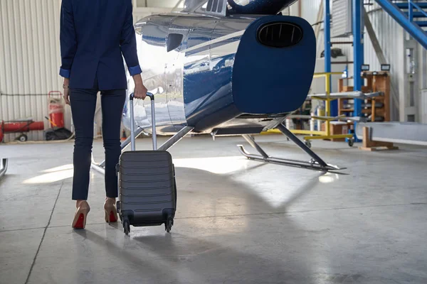 Geschäftsfrau mit Gepäck im Flugzeughangar — Stockfoto