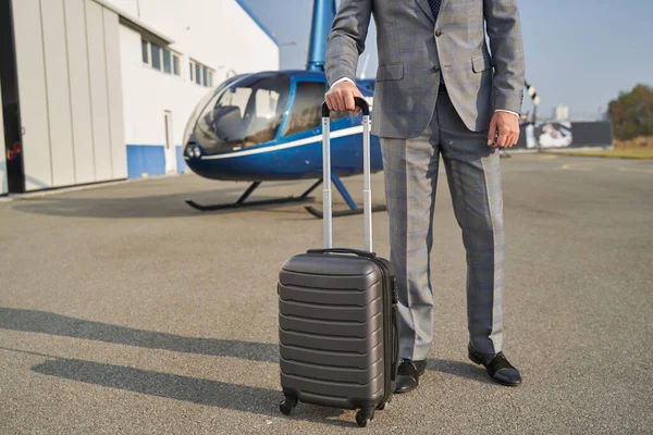 Eleganter Mann mit Gepäck steht neben Hubschrauber — Stockfoto