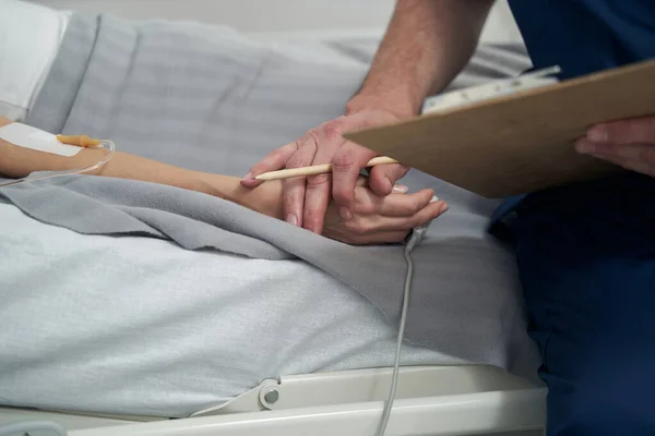 Läkare som kontrollerar patientens hälsotillstånd under avdelningsrundan — Stockfoto