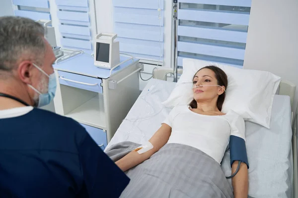 Läkare som övervakar kvinnliga patienter under intravenös behandling — Stockfoto