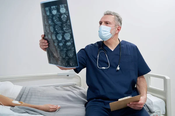 Neurólogo mirando imágenes cerebrales de pacientes mujeres — Foto de Stock