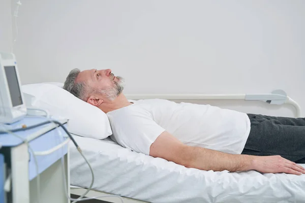 Uspokajający dojrzały mężczyzna przebywający w szpitalu — Zdjęcie stockowe