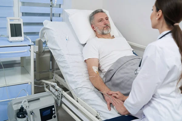 Paziente maschio che guarda il medico curante durante la terapia endovenosa — Foto Stock