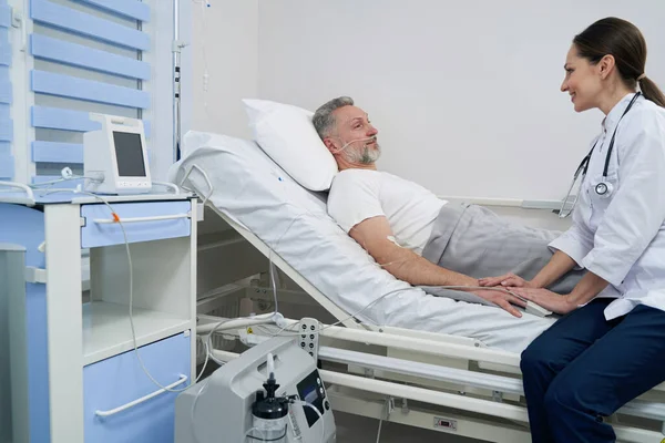 酸素療法中に彼の出席医師と通信する男 — ストック写真