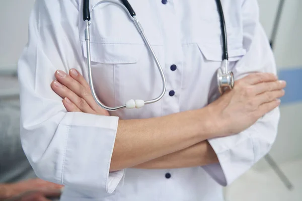 Biała pani doktor ze stetoskopem stojąca w miejscu pracy — Zdjęcie stockowe