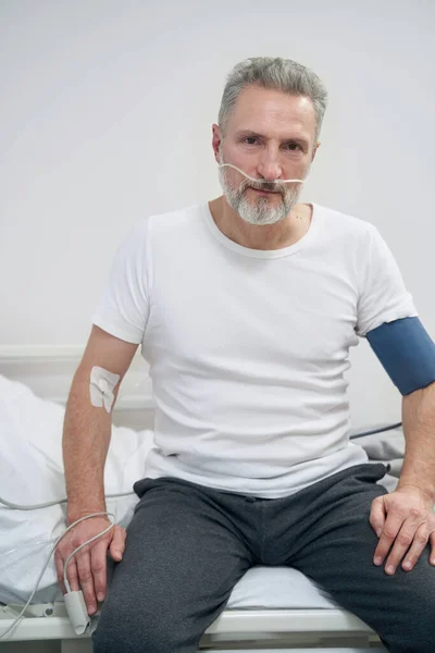 Nemocný muž dostat doplňkový kyslík přes nosní trubice — Stock fotografie