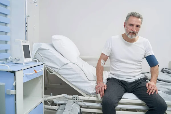 Vuxna manliga patienten sitter ansluten till syrekoncentrator — Stockfoto