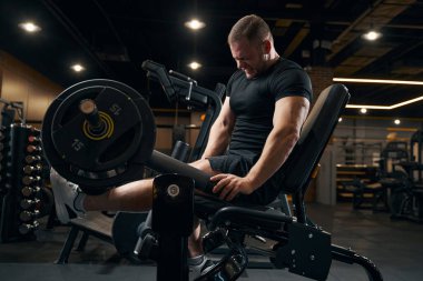 Güçlü halterci egzersiz ekipmanları üzerinde çalışıyor.