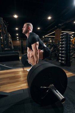 Sakin genç erkek atlet kaldırma egzersizi yapıyor.