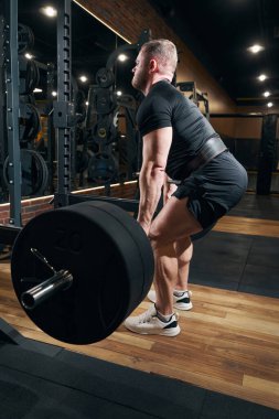 Vücut geliştirici spor salonunda kaldırma egzersizi yapıyor.