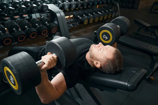 Мужчина выполняет упражнения грудной пресс в тренажерном зале — стоковое фото