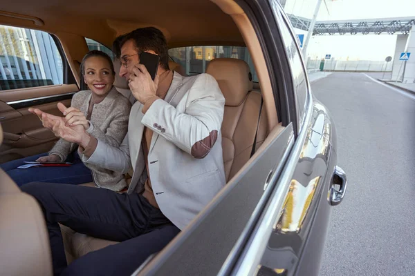 Hombre sentado en el coche y teniendo una llamada telefónica — Foto de Stock