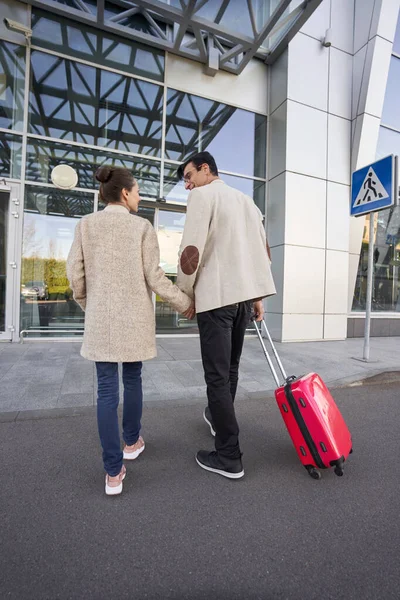 Par går tillsammans inne på flygplatsen med bagage — Stockfoto