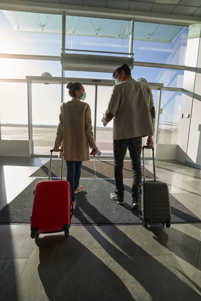 Resenärer som pratar med varandra när de går med bagage — Stockfoto