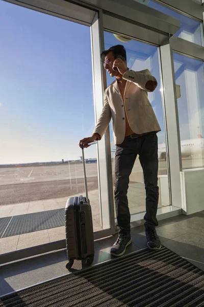 Umtriebiger Mann telefoniert in der Nähe seines Gepäcks — Stockfoto