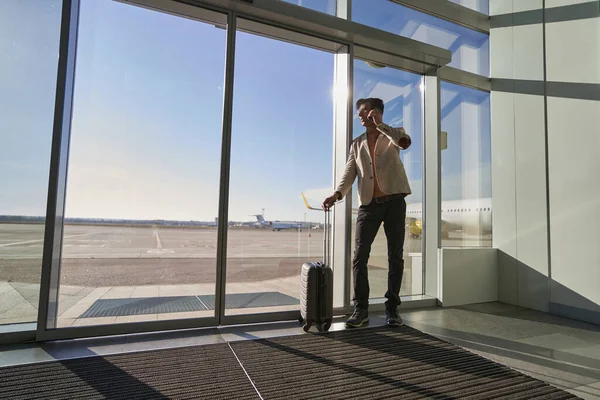 Person giving a look at runway while having phone call — Stock Photo, Image