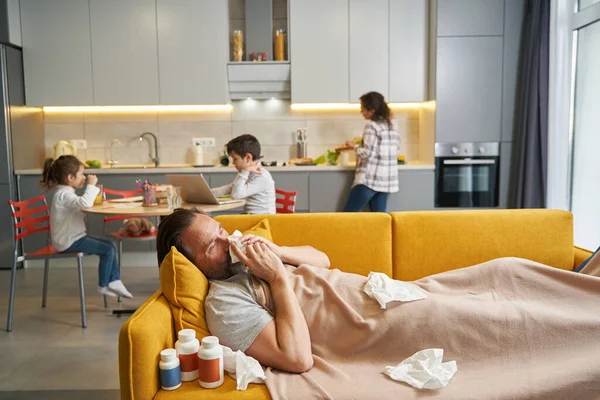Padre enfermo que sufre de frío en el sofá de la cocina — Foto de Stock
