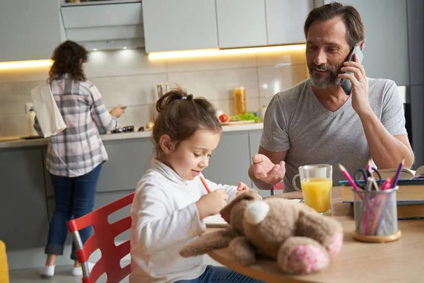 Mann zeigt auf Tochter und malt in Notizbuch — Stockfoto