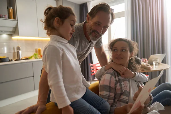 Chica y sus padres estudiando pintura en la cocina —  Fotos de Stock