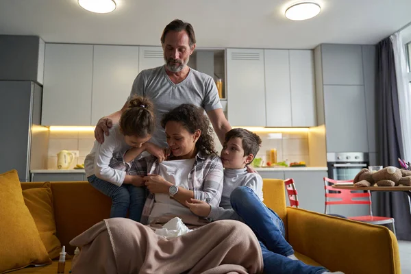 Filho e filha apoiando mãe doente no sofá — Fotografia de Stock