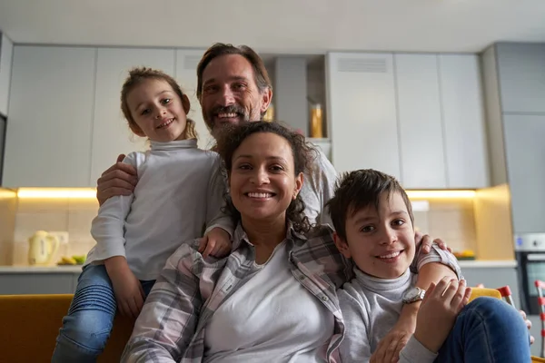 Família alegre olhando para a câmera e sorrindo — Fotografia de Stock