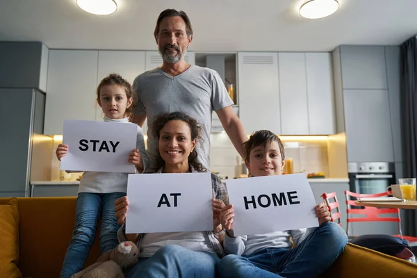 Familiares segurando sinais sobre ficar em casa — Fotografia de Stock