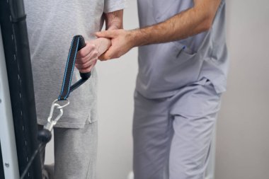 Kablo makinesinin sapını tutan yaşlı bir hastanın eli