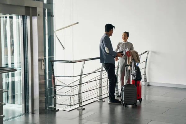 Couple avec documents de voyage et bagages appuyés sur une rampe d'escalier — Photo