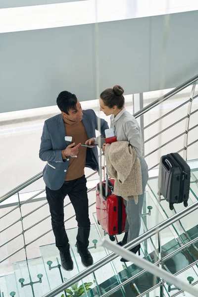 Hombre conversando con su compañera femenina en escalera de cristal —  Fotos de Stock