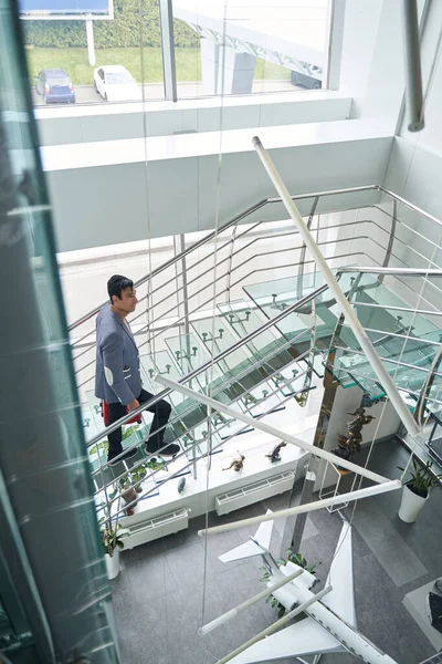 Stylish middle-aged gentleman with baggage ascending staircase — Stock Photo, Image