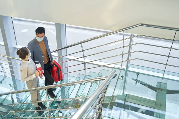 Toeristisch koppel met gezichtsmaskers op glazen trap — Stockfoto