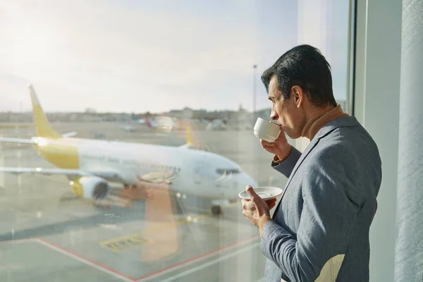 Kaukasier trinkt Kaffee in Flughafenlounge — Stockfoto