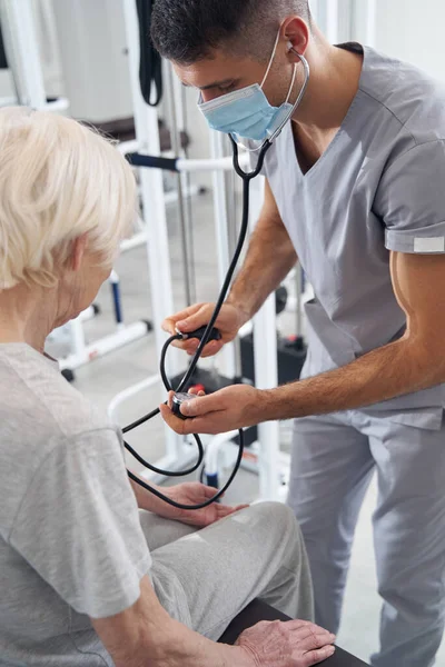 Médico masculino mirando el manómetro del monitor de presión arterial — Foto de Stock